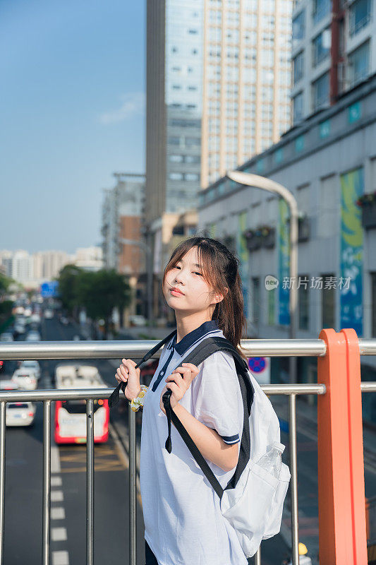 亚洲女孩在一个阳光明媚的日子放学回家