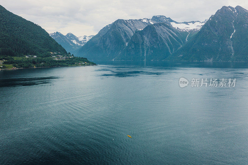 在挪威风景优美的峡湾上，一名女性旅行者划皮艇的鸟瞰图