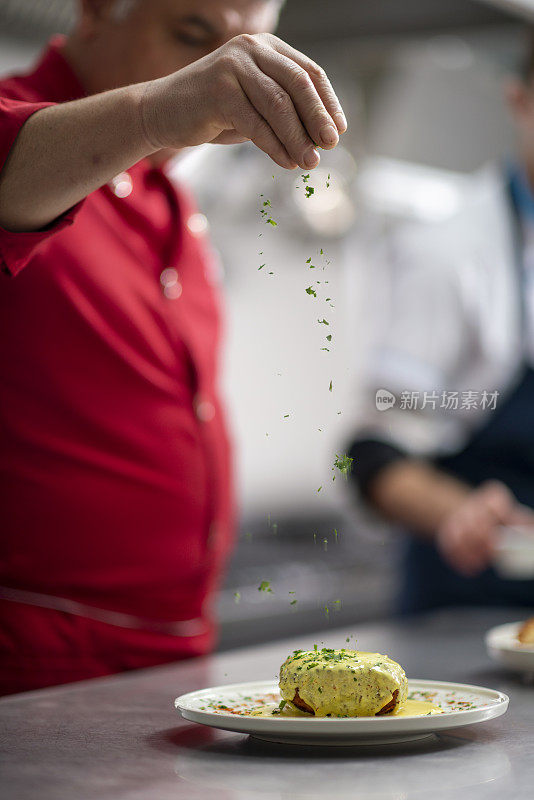 厨师正在厨房里装饰盘子