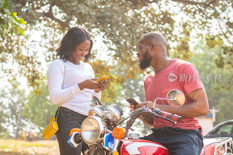 一对黑人夫妇在公园里用智能手机分享内容