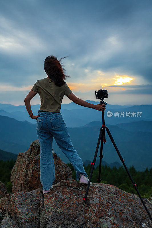 女摄影师在山顶拍摄夜景