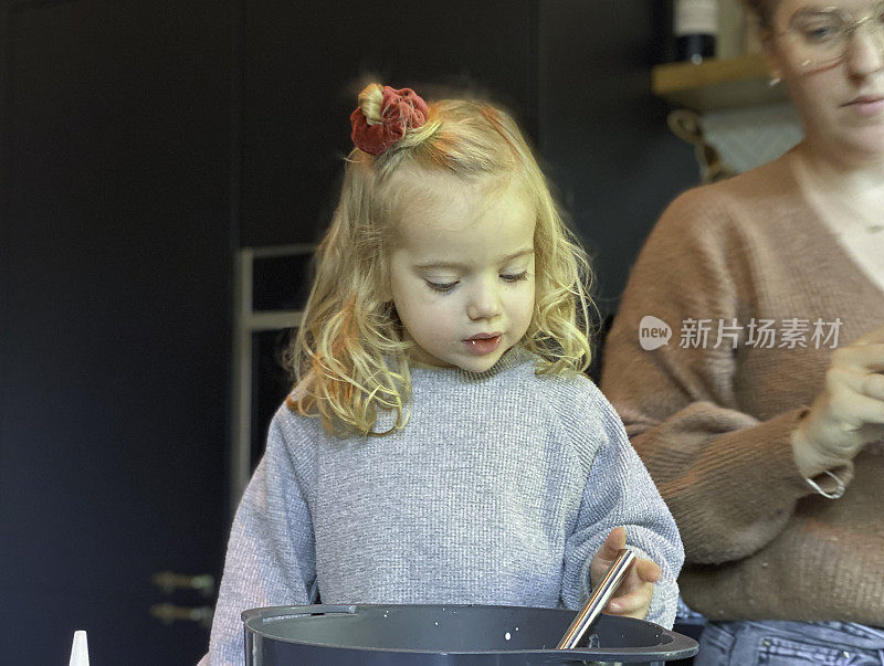 蹒跚学步的小女孩帮妈妈烤苹果派