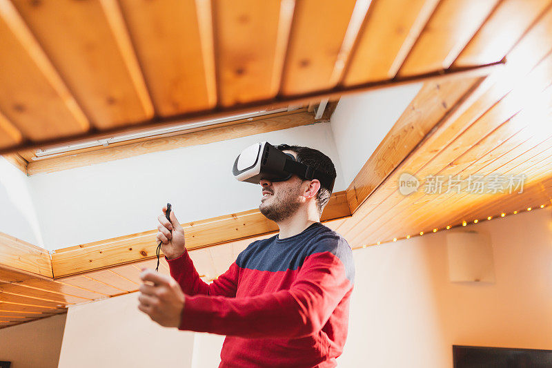 一个惊讶的男人在家里使用虚拟现实眼镜的肖像。