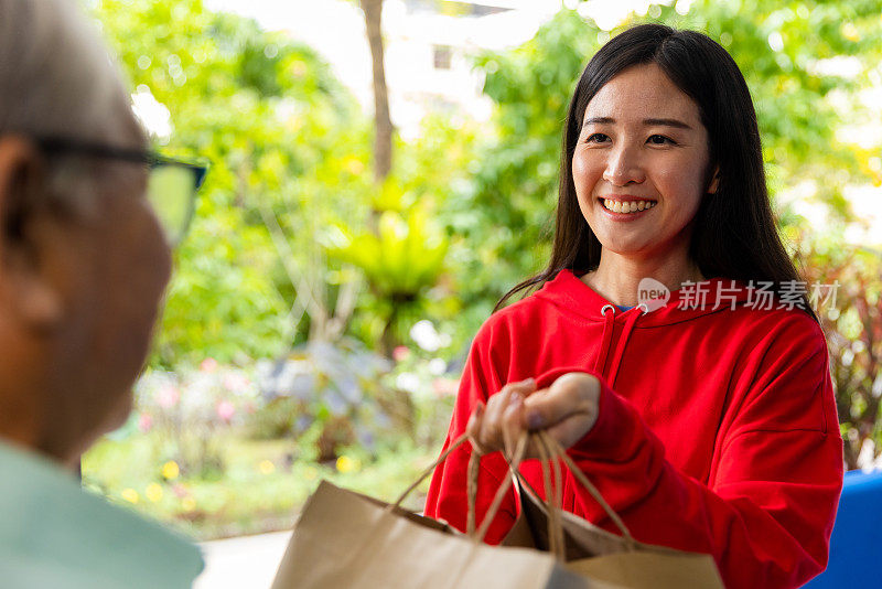 女人在家里给老人送食物。