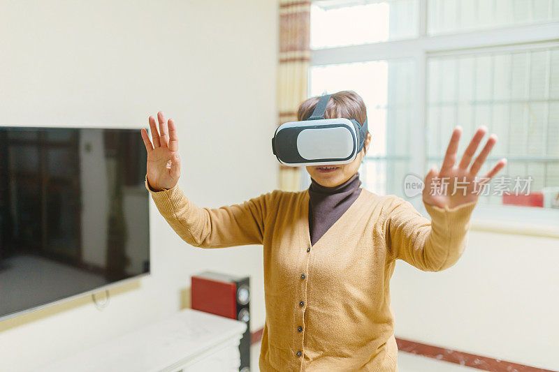 一位中年妇女沉浸在VR眼镜中——科技与生活，健康的生活方式
