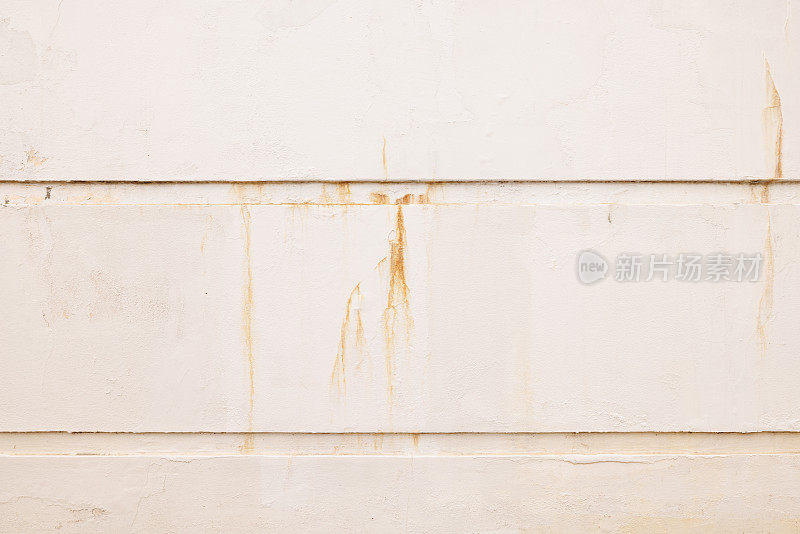 米色混凝土墙的一部分，锈迹斑斑