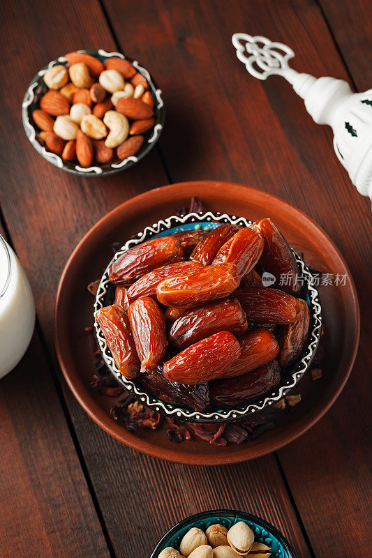斋月和开斋的穆斯林食物。把枣核、坚果和牛奶放在木板上。传统的开斋食物