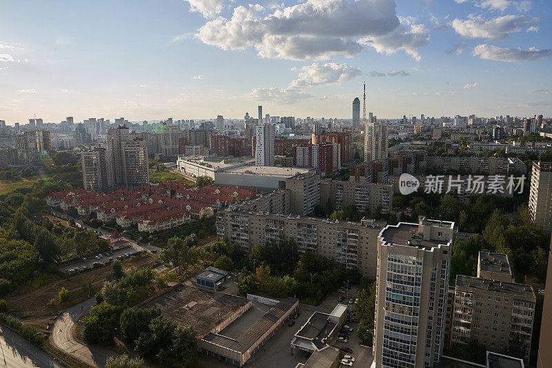 背景是公寓楼。从上面可以看到城市密集的建筑。蓝天白云。俄罗斯——2022年8月14日，高楼大厦从高处落下。高质量照片