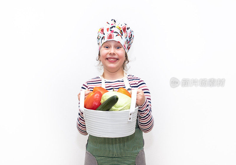 一个8岁的白人女孩，打扮成厨师，手里拿着一大篮子蔬菜，面带微笑。一个女孩情绪化的脸。