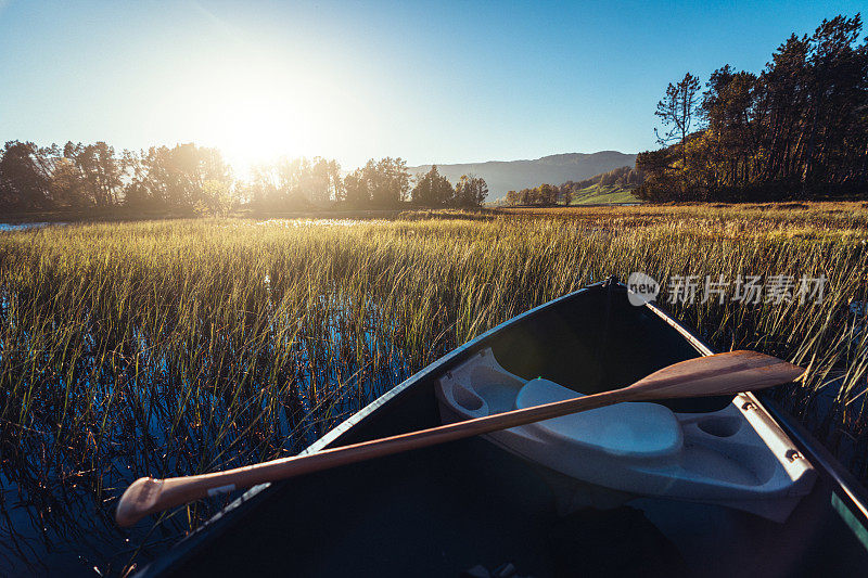 户外探险:日落时在湖中划独木舟