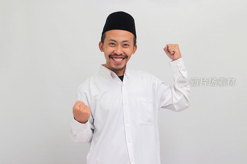 自信的印尼年轻男子正在做一个强有力的手势，孤立在白色背景上