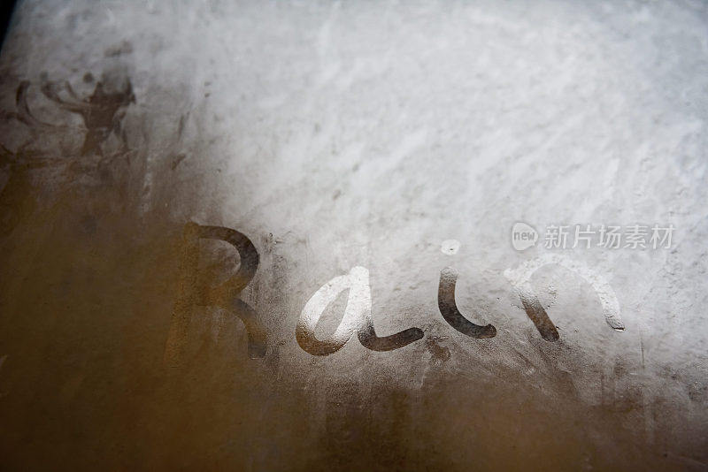 在一个下雨的冬日，有雾的湿水晶上写着“雨”字。
