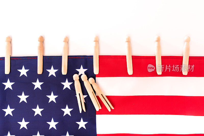 美国国旗用衣夹固定在白色背景上，为文字留出复制空间。