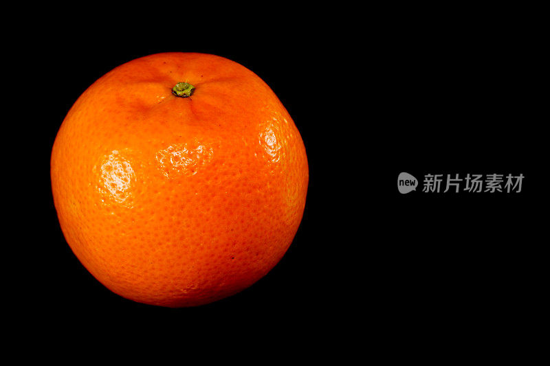 新鲜的橙色孤立在黑色背景上，近距离查看复制空间单个对象