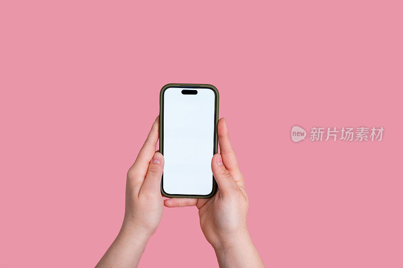 女人拿着粉红色背景的空白屏幕的智能手机