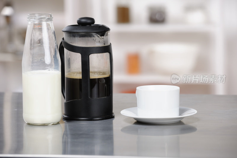 厨房工作台上的牛奶、咖啡、杯子和碟子