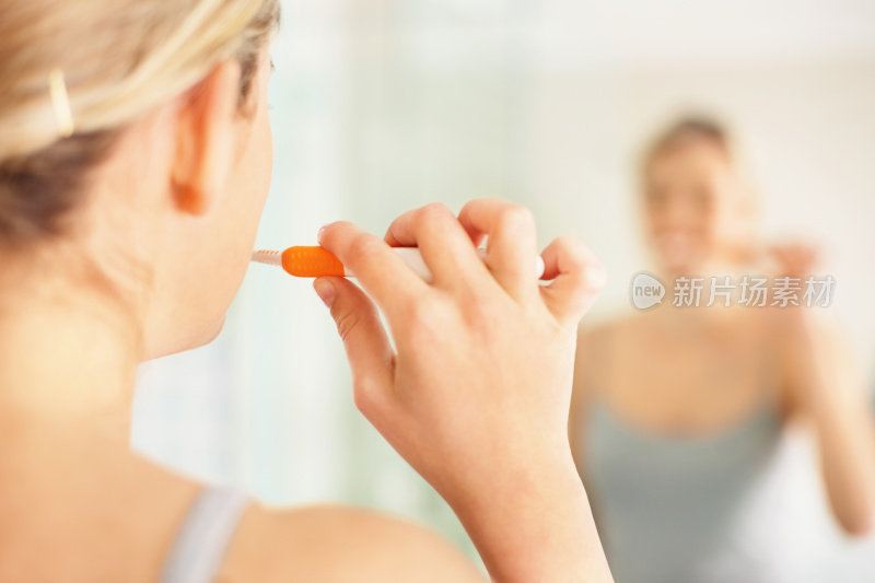年轻的女士正在刷牙