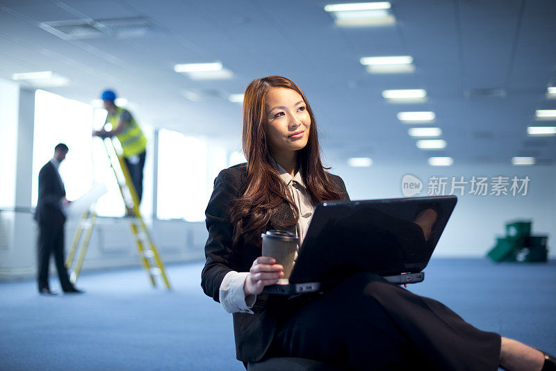 年轻女商人在空荡荡的办公室里