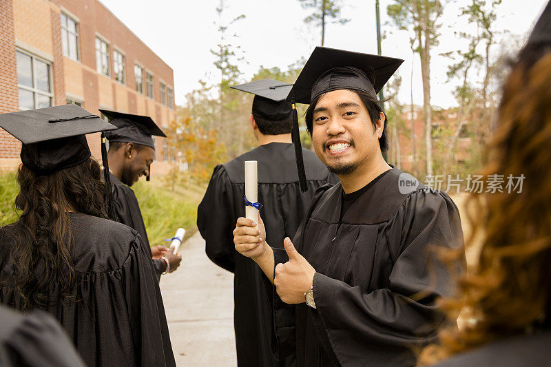 教育背景:兴奋的亚洲男性毕业生和大学校园里的朋友。