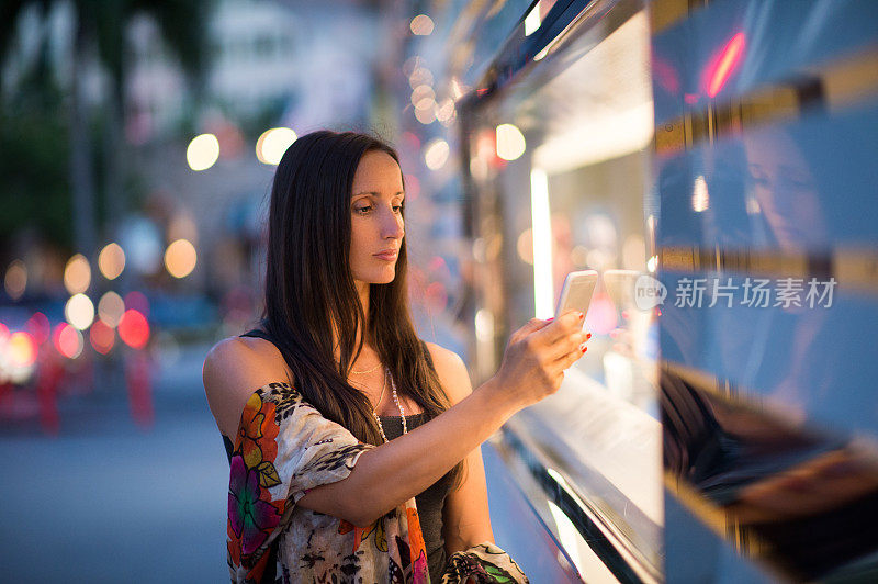 一个女人在商店橱窗前拍照