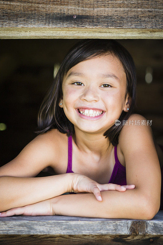小女孩微笑着在外面玩。