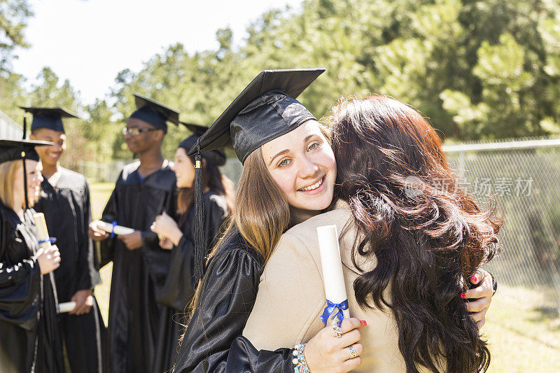 大学，高中学生毕业典礼后拥抱妈妈。