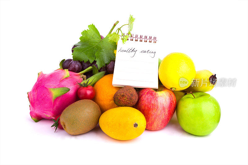 健康饮食:水果品种和笔记本孤立在白色的背景