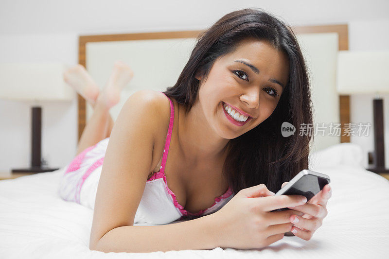 女人在床上玩智能手机