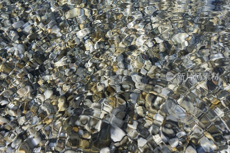 沙滩卵石下的涟漪水抽象