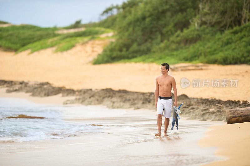 在热带夏威夷的海滩上散步的年轻人