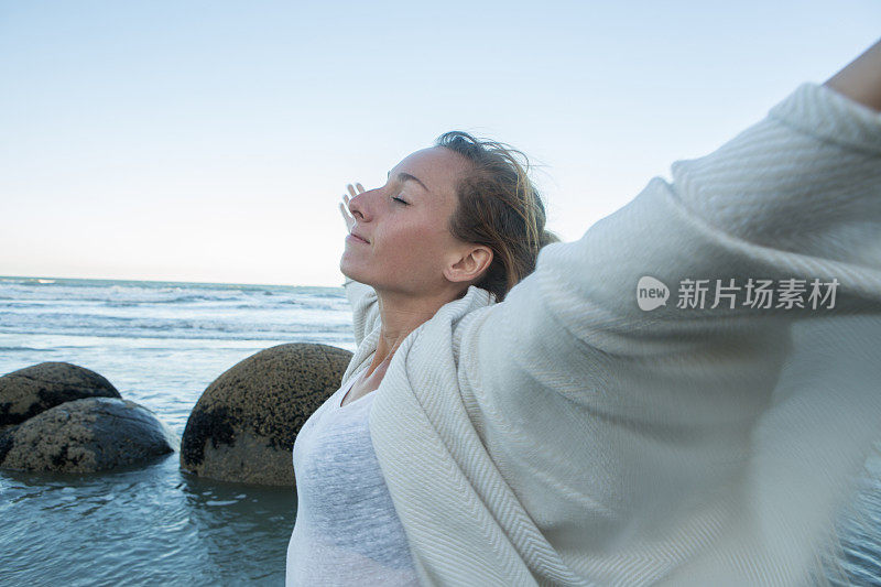 这是一幅年轻女子的肖像，她的手臂在圆石附近张开