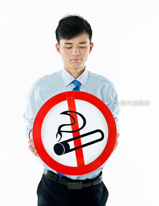年轻的商人举着禁止吸烟的牌子