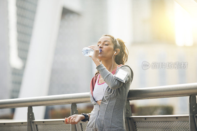 女跑步者正在休息和喝水
