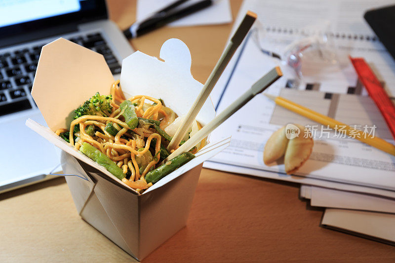 桌上放着中餐盒。在办公室吃饭。加班的概念。
