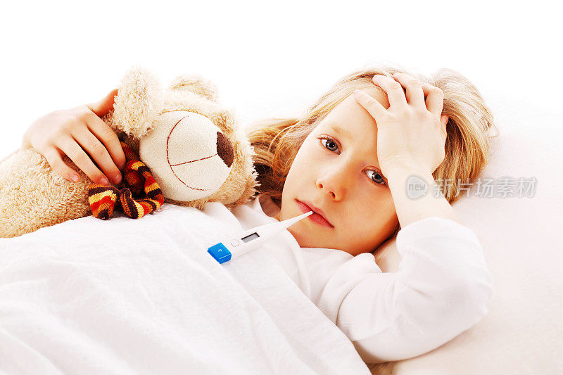 小女孩和她的泰迪熊躺在床上。