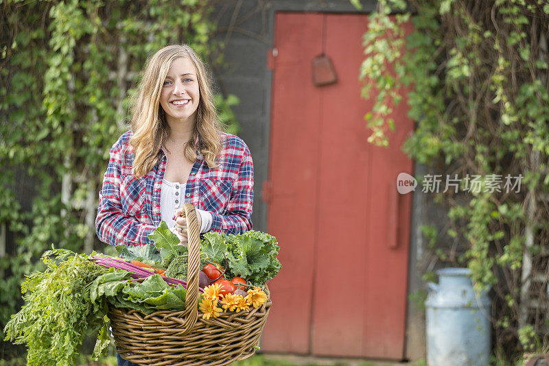 年轻女子提着一大篮新鲜的田园农产品