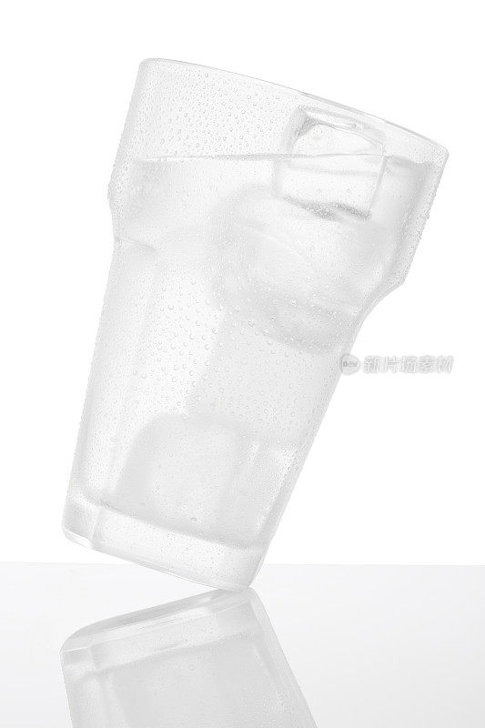冰冷倾斜的水杯覆盖着水珠凝结