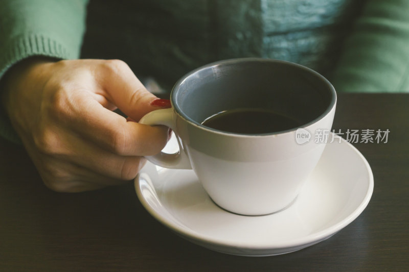 女人拿着半杯空咖啡在咖啡馆