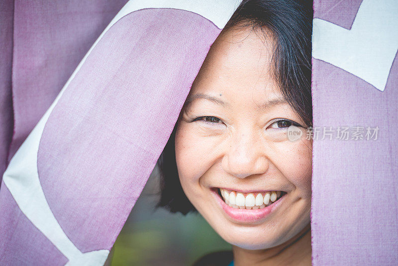 在日本京都，窗帘后微笑的日本女人的肖像