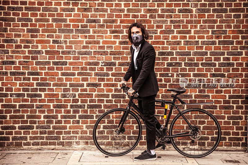 在伦敦市中心，戴着防污染面罩的自行车通勤者