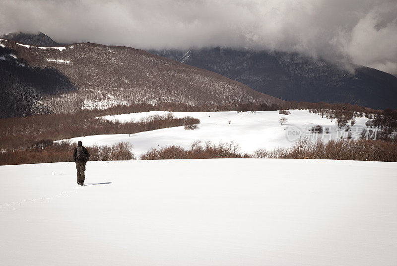 一个孤独的人在雪山上徒步旅行