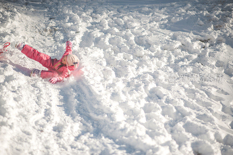 孩子在雪地上滑倒了