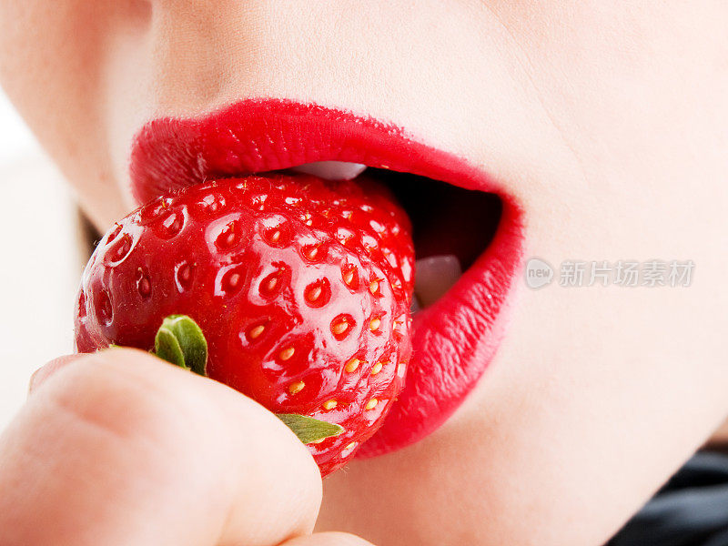 年轻女子吃草莓