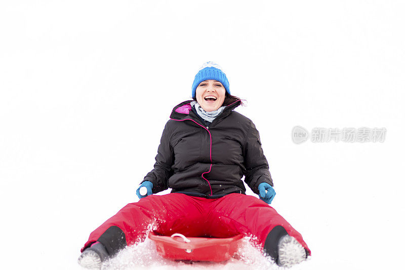 快乐的女人微笑着在雪地上滑雪，冬天的背景