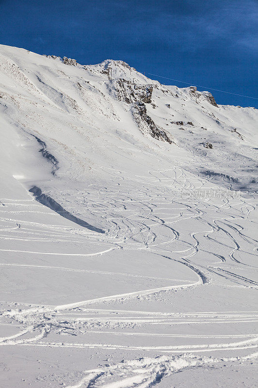 有滑雪痕迹的雪山边