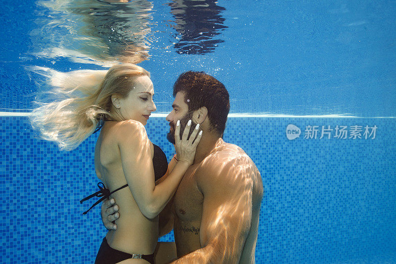 水下情侣相爱男人和女人在游泳池里
