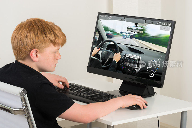 男孩在电脑上玩汽车游戏