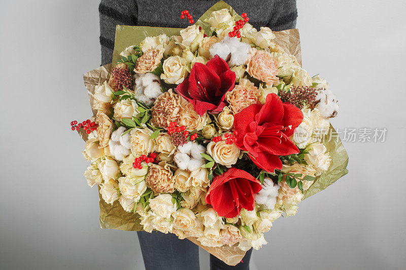 女人手里拿着绣球花的花束。五颜六色的玫瑰和各种颜色的花混搭