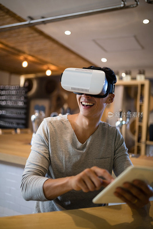 在餐厅使用虚拟现实耳机和数字平板电脑的人
