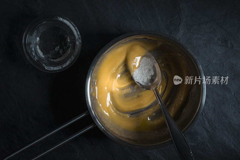 在平底锅里融化的黄油放在灰色的石头上
